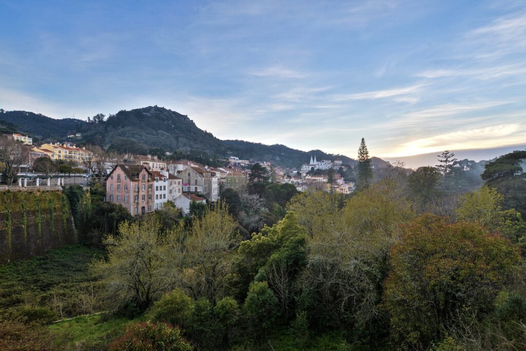 paisaje-de-colinas-cubiertas-de-edificios-y-bosques-bajo-un-cielo-nublado-durante-la-puesta-de-sol-1024x684.jpg